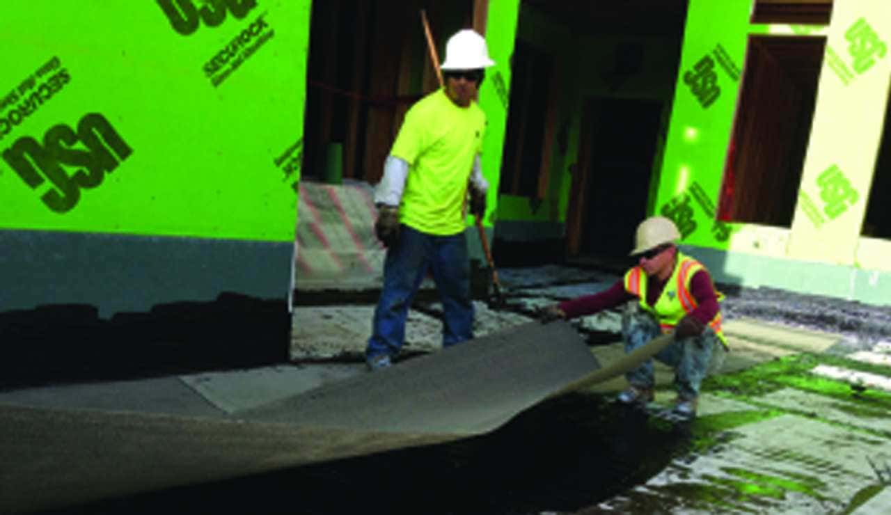 Construction workers installing a water proofing system
