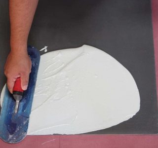 Worker applying Pli-Dek waterproofing solution with hand trowel