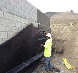 Below Grade Waterproofing: Construction Worker spraying wall